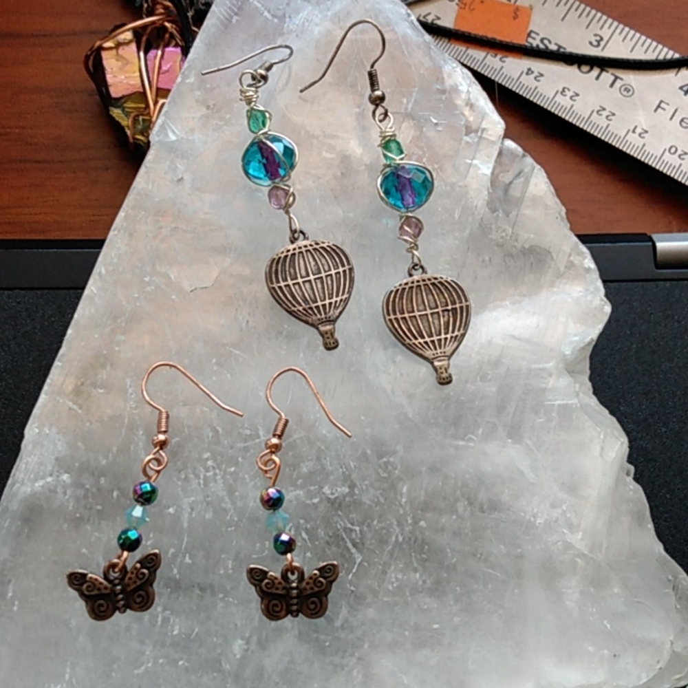 Two super cute pairs of earrings with butterflies and hot air balloons